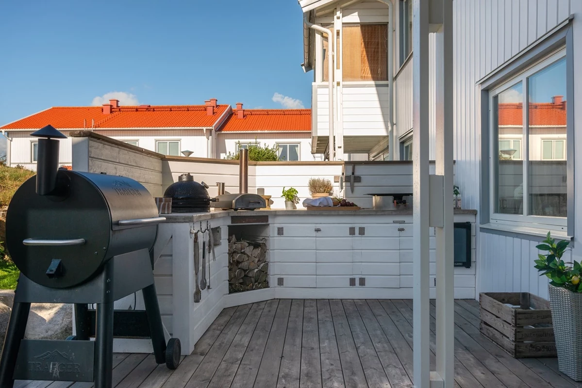...med trälagd terrass och utekök