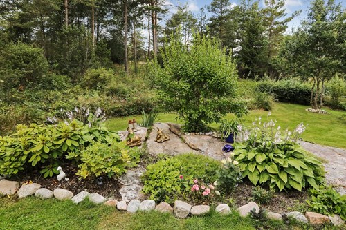 Grönskande och prunkande trädgård och omgivningar gör här extra trivsamt