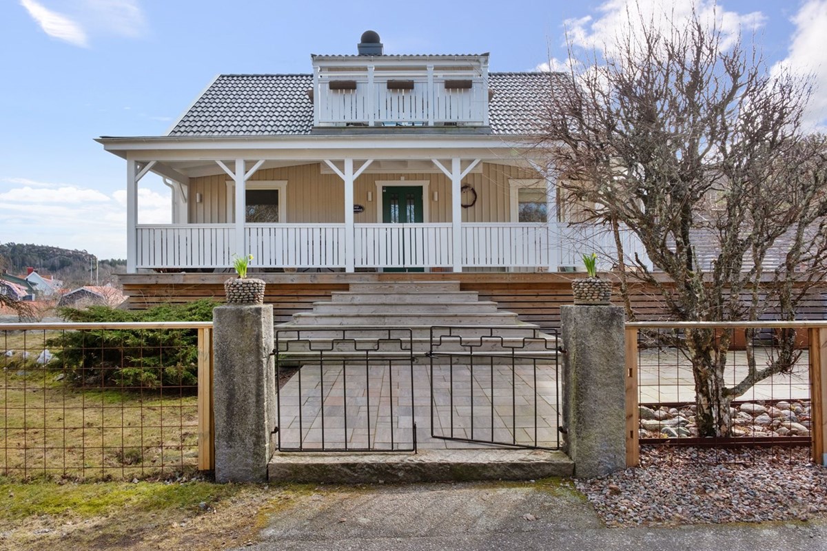 Pampig entré med granitstolpar och amerikansk veranda