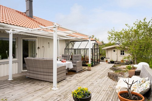 En ljuvlig uteplats med både uterum/ växthus och pergola